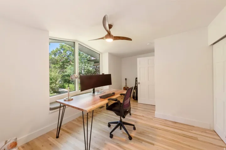 Room with light wood-finish flooring and white walls
