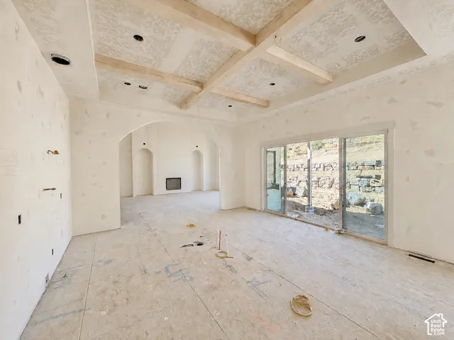 Vaulted ceiling with exposed wood beams and recessed lighting