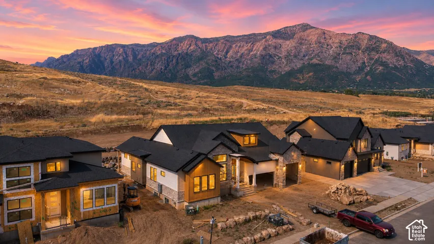 New construction homes featuring multi-tonal exteriors with natural stone accents, dark roofing, and multiple garage bays