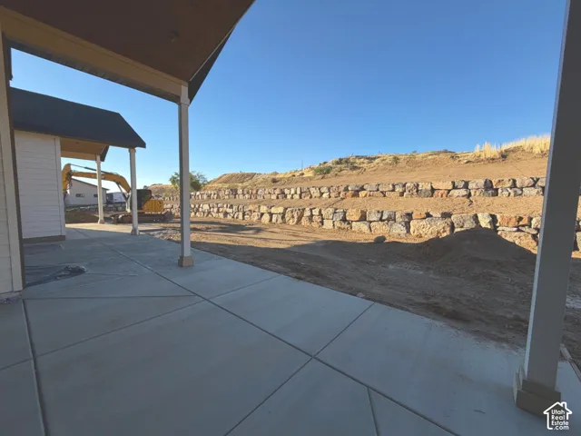 Covered patio with concrete flooring overlooking the hillside cemetery grounds