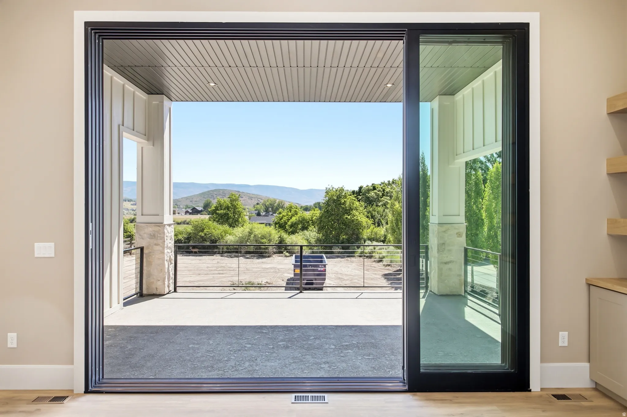 Expansive sliding glass doors opening to a covered patio