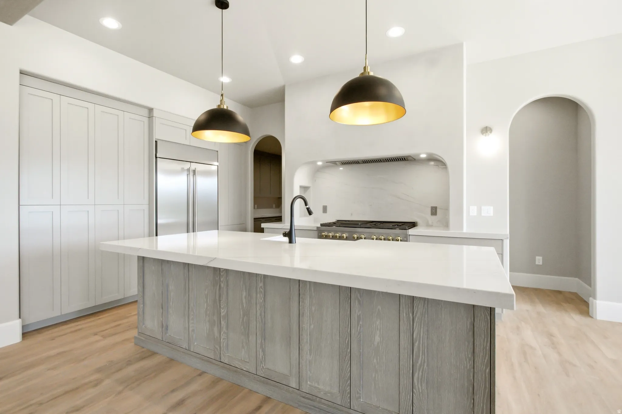 Kitchen featuring a large central island with a white countertop and wood-finish paneling