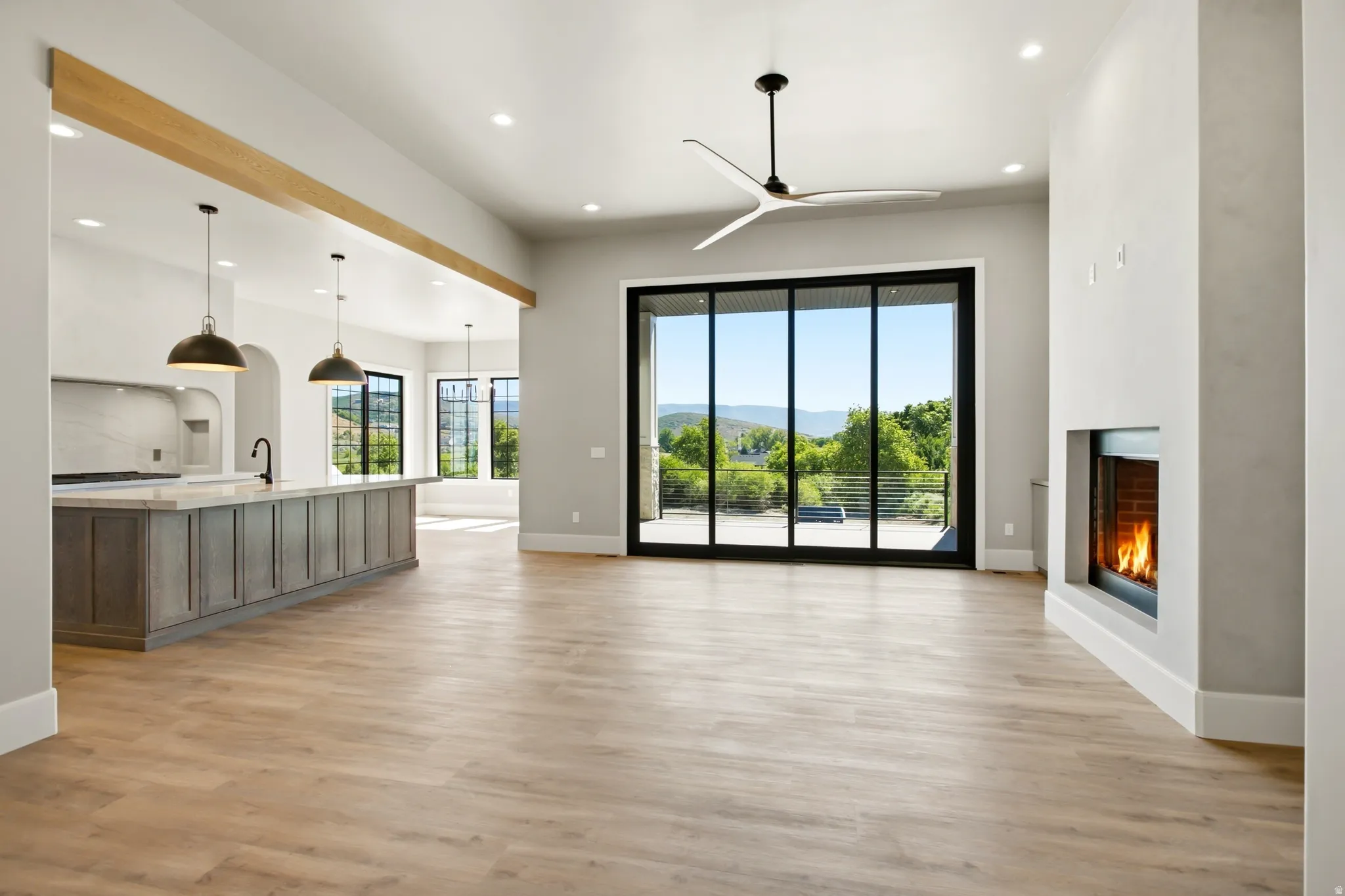Open-concept living space featuring a modern linear fireplace, and a contemporary ceiling fan