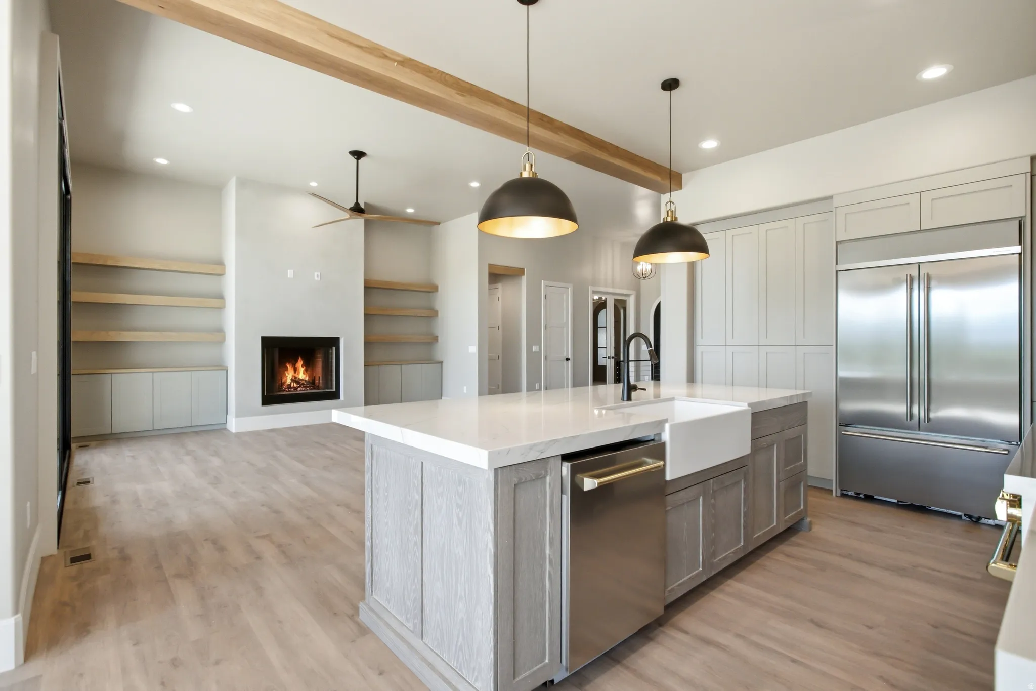 Kitchen island featuring a farmhouse sink, stainless steel dishwasher, and a light gray wood-finish base