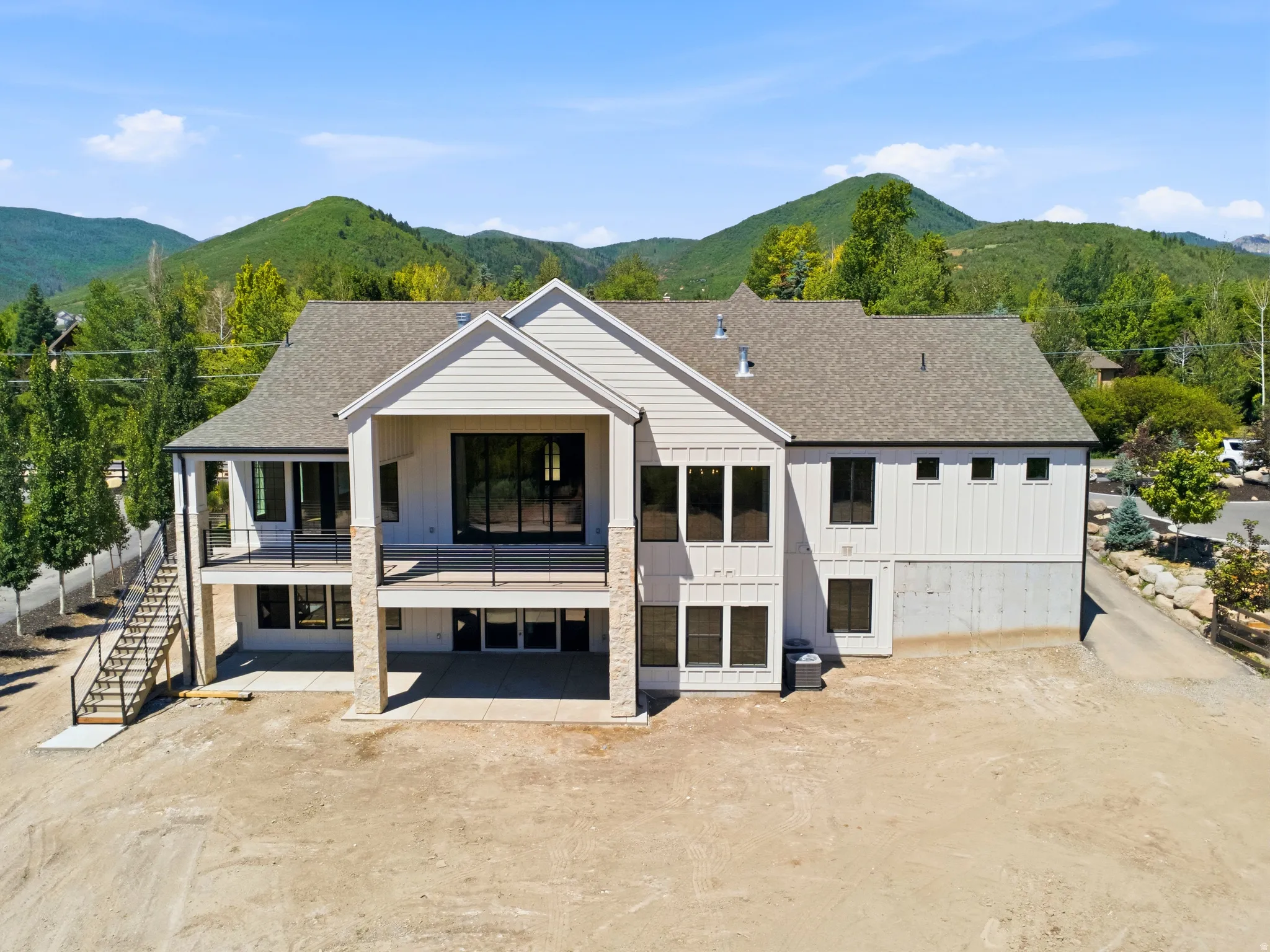 Modern two-story residence with a multi-level design and a prominent mountain backdrop
