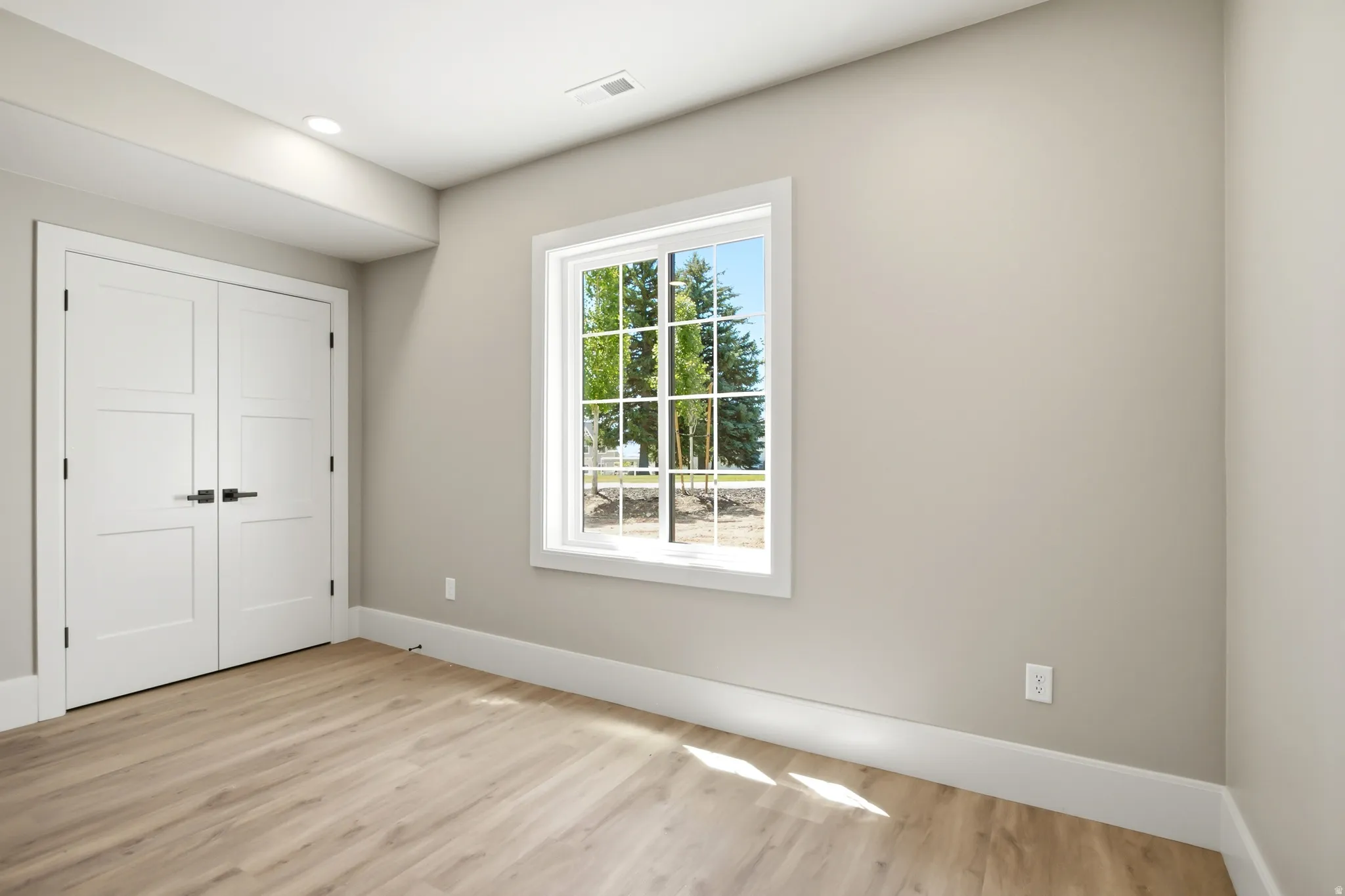 Light-filled interior space featuring a white-framed window, and neutral painted walls