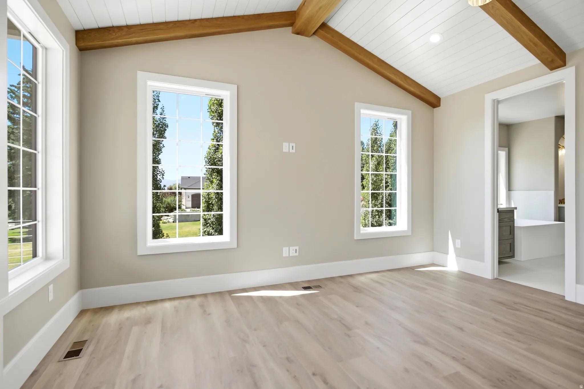 Primary Bedroom vaulted ceiling featuring exposed wood beams and shiplap paneling