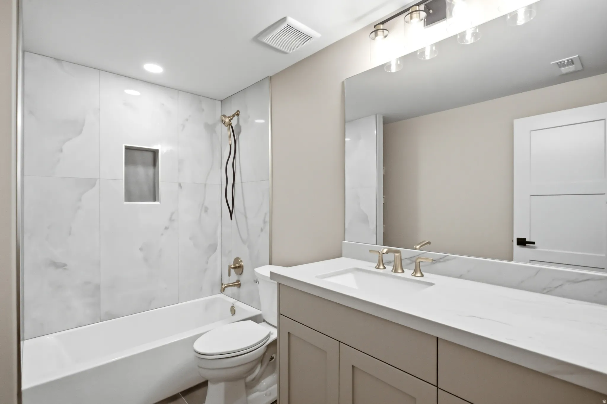 Bathroom featuring a single vanity with an integrated sink, quartz-finish countertop, and brushed nickel faucet