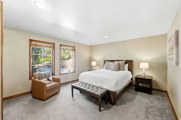 Carpeted room featuring two windows with wood-trim framing, recessed lighting, and a neutral wall color