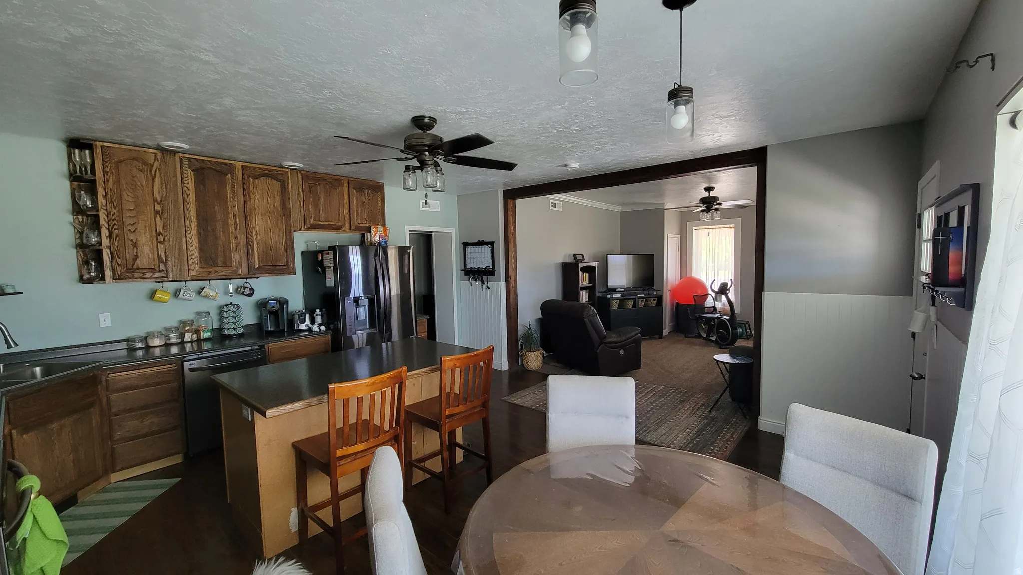 Kitchen featuring wood cabinetry, stainless steel appliances, and a central island with seating