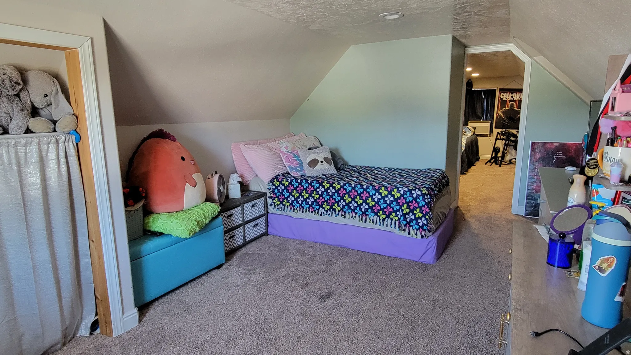 Carpeted room featuring a built-in storage bench, sloped ceilings, and a framed doorway