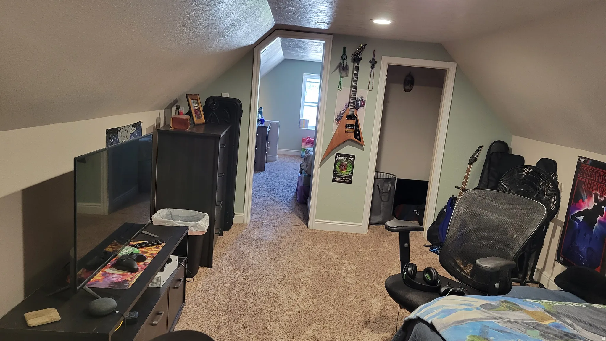 Carpeted attic space featuring sloped ceilings, light green wall paint, and recessed lighting