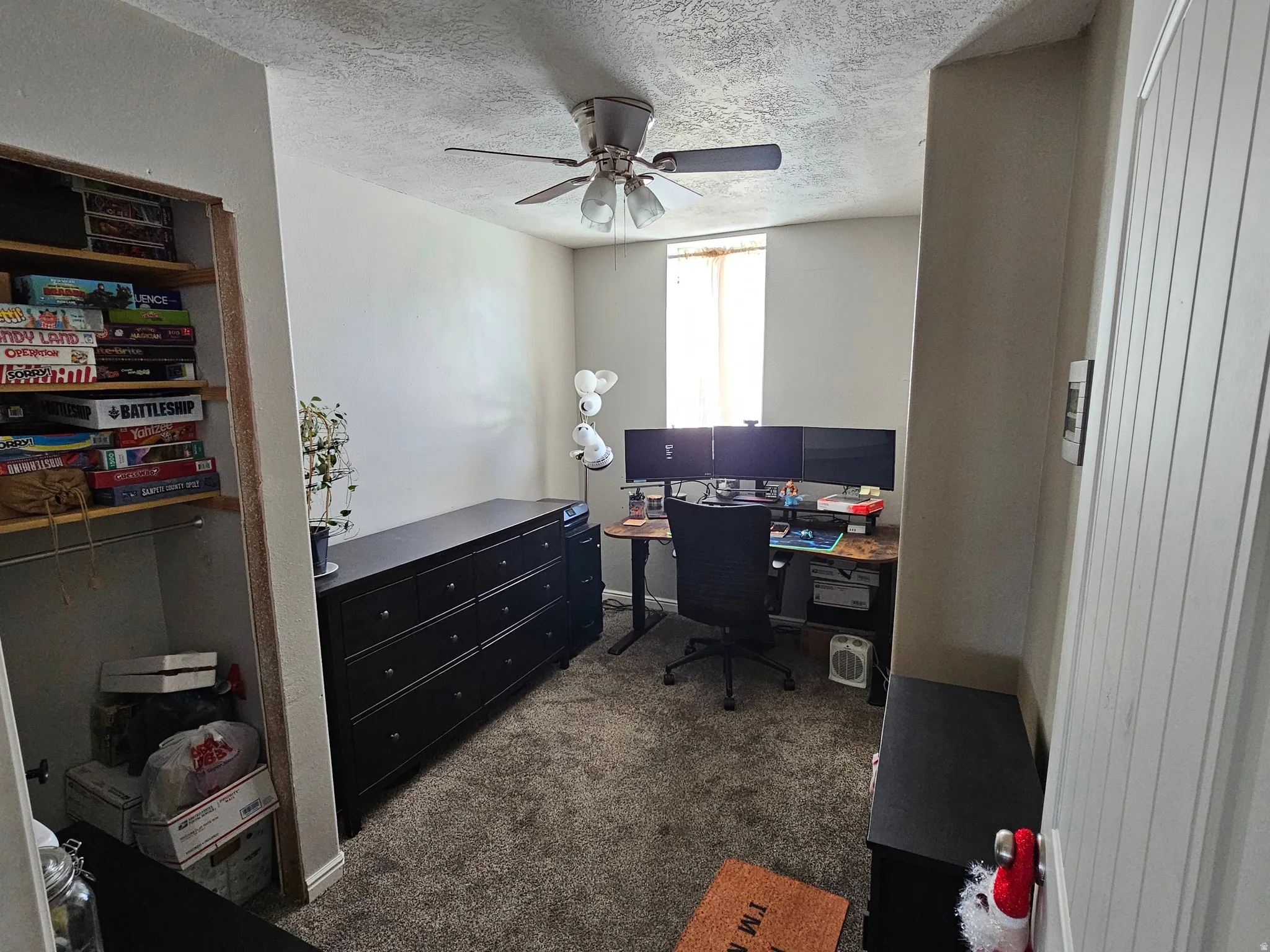 Room featuring neutral wall tones, textured ceiling, and a ceiling fan