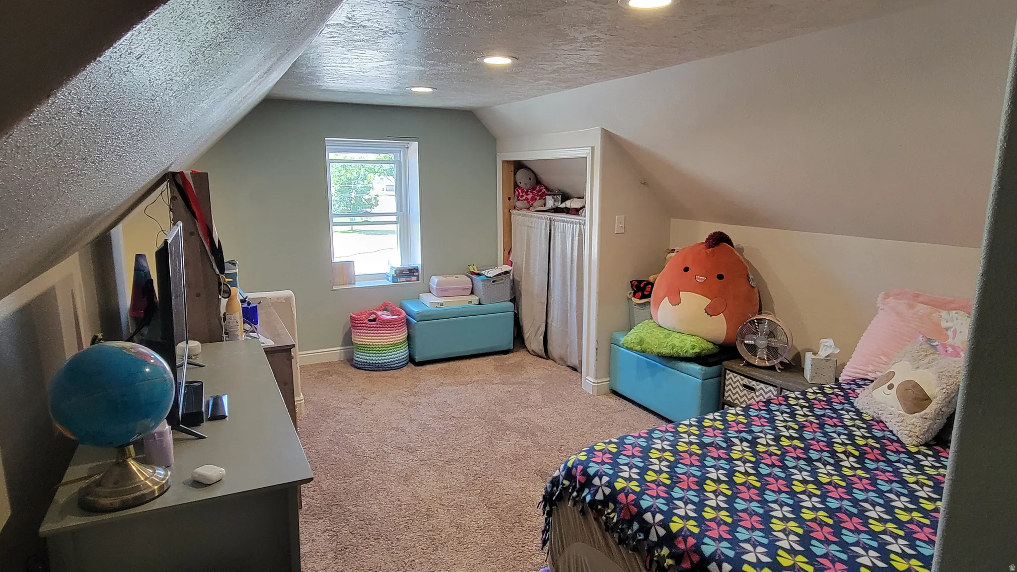 Carpeted room with recessed lighting and a window