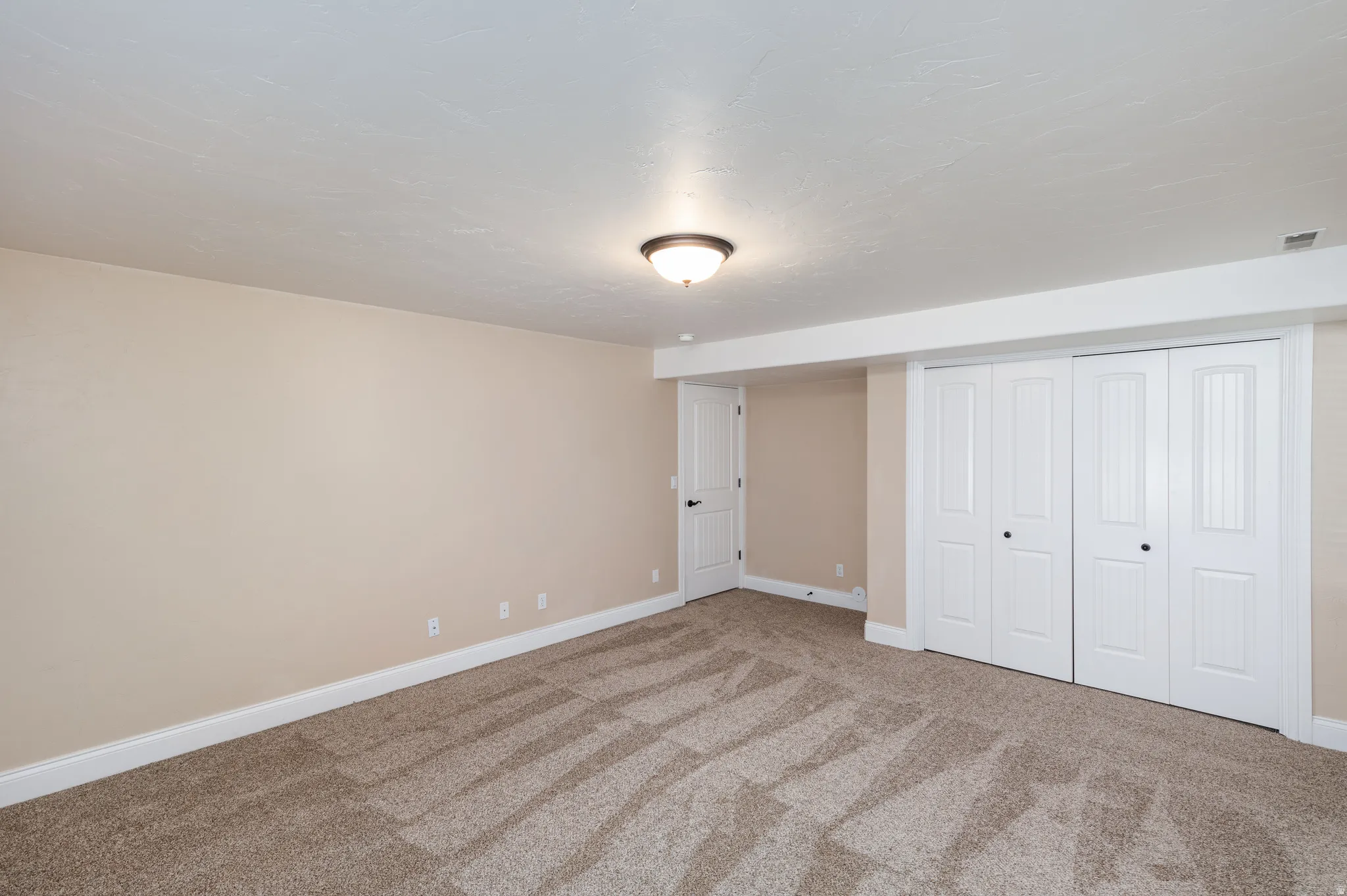 Neutral-toned walls complement the textured carpet flooring
