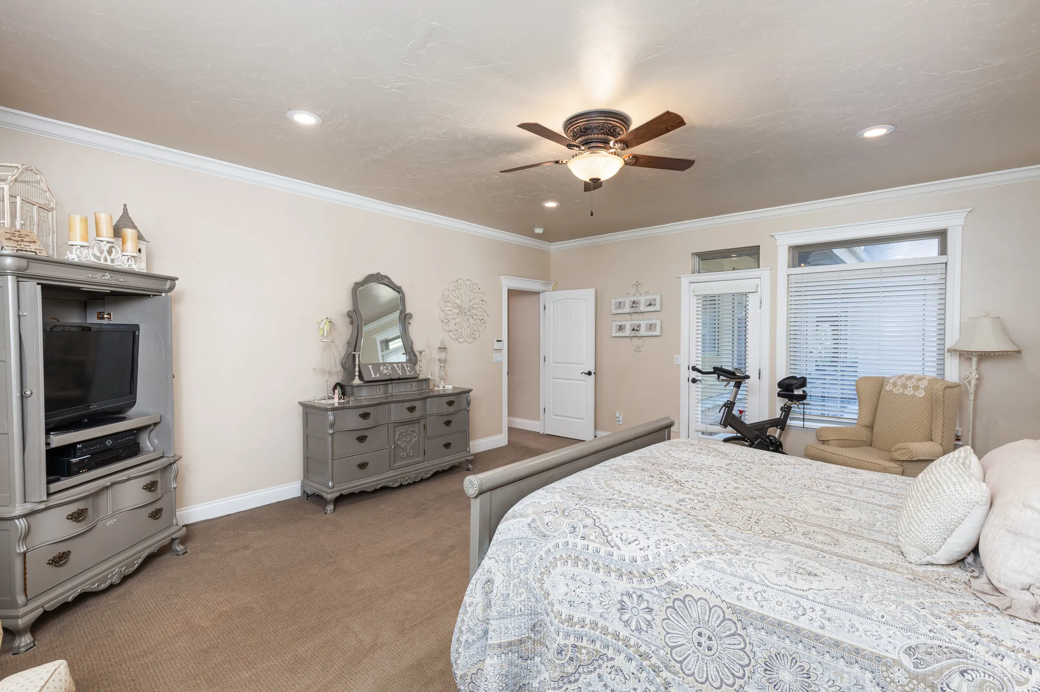 Carpeted room featuring crown molding, recessed lighting, a ceiling fan, and a glass-paned door with transom window