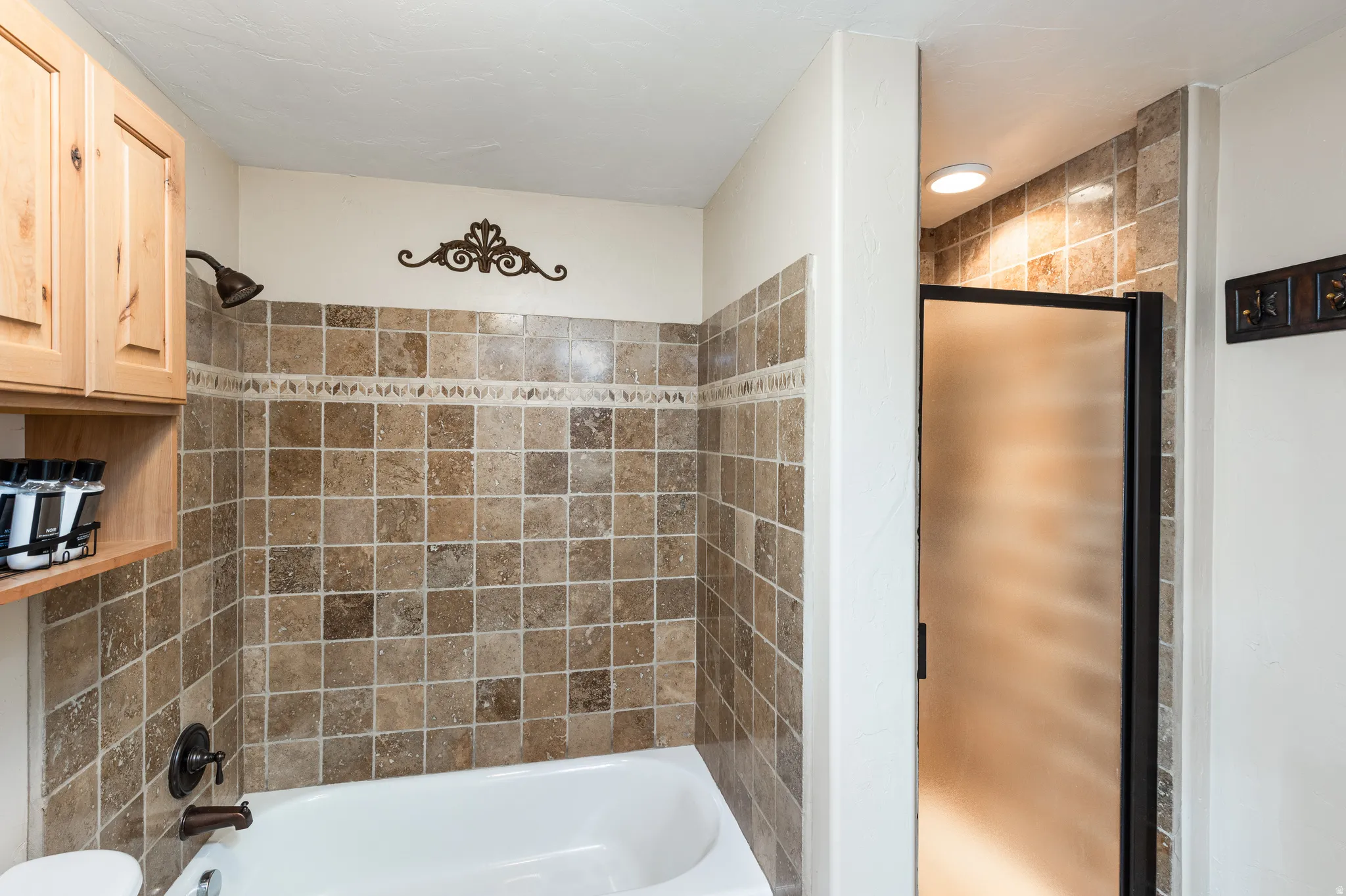 Bathroom featuring a tiled shower/tub combination with a dark bronze showerhead and faucet
