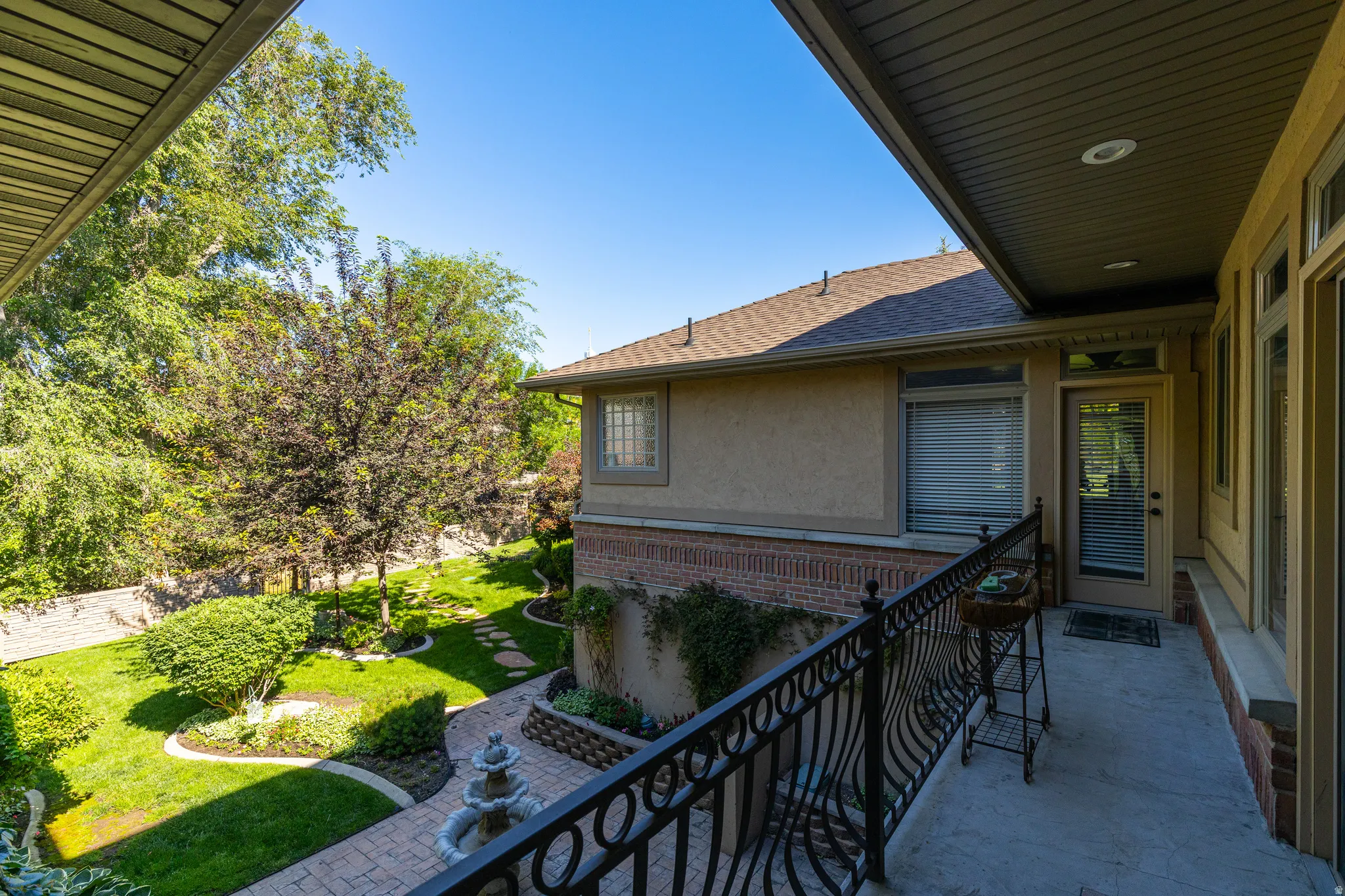 Exterior balcony featuring an ornate wrought-iron railing and concrete flooring