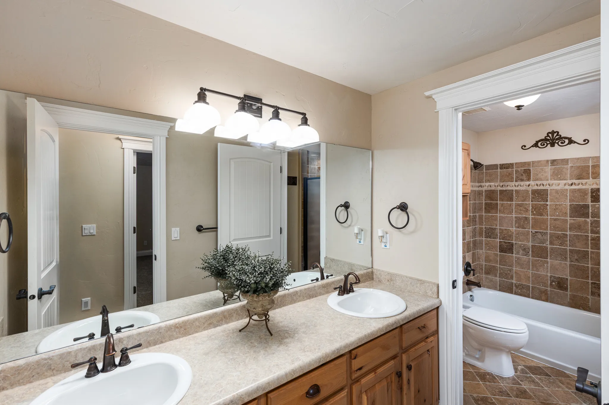 Dual vanity with integrated sinks, wood-finish cabinetry, and laminate countertop