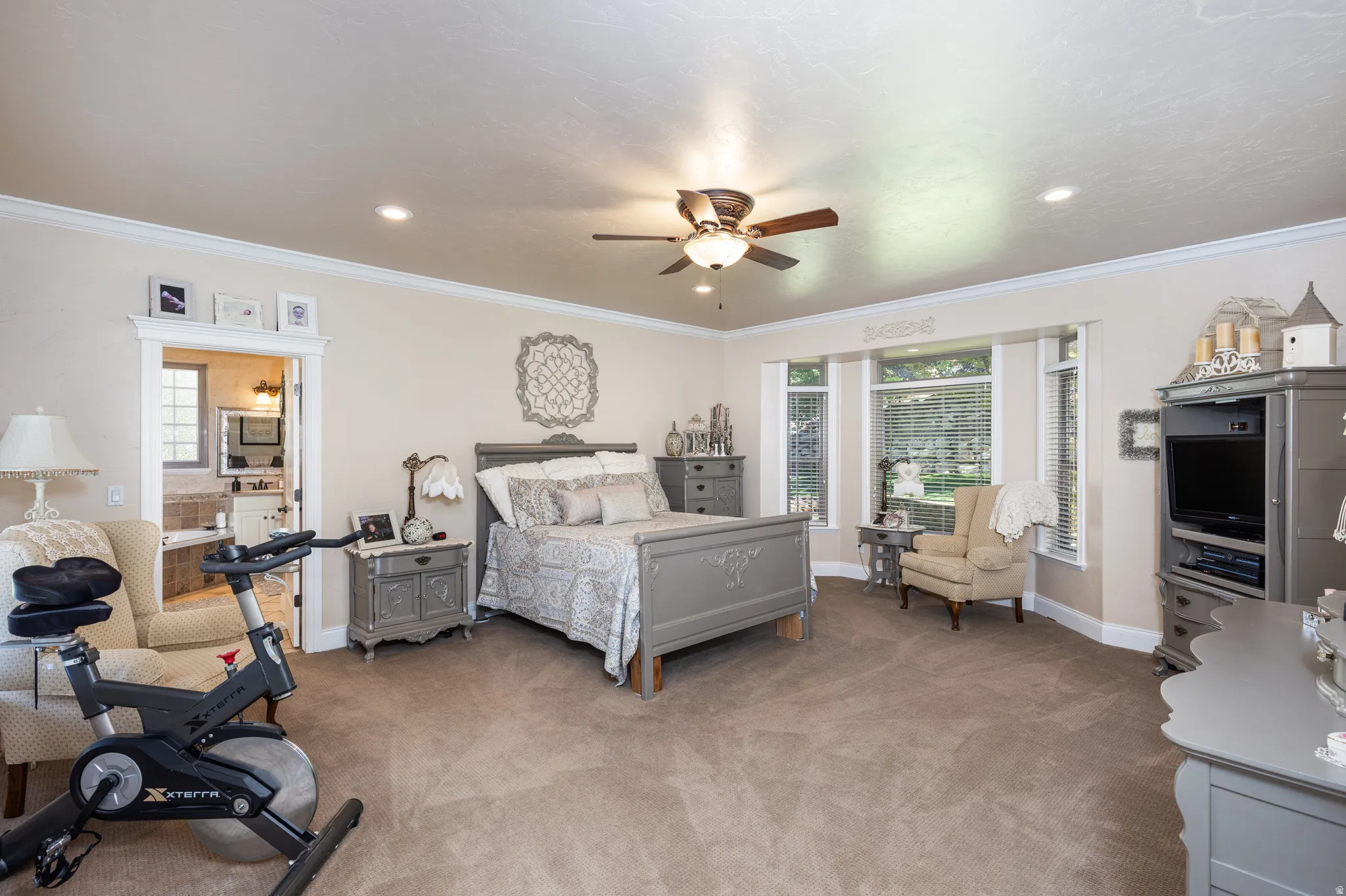 Spacious room with plush carpeting, crown molding, and recessed lighting
