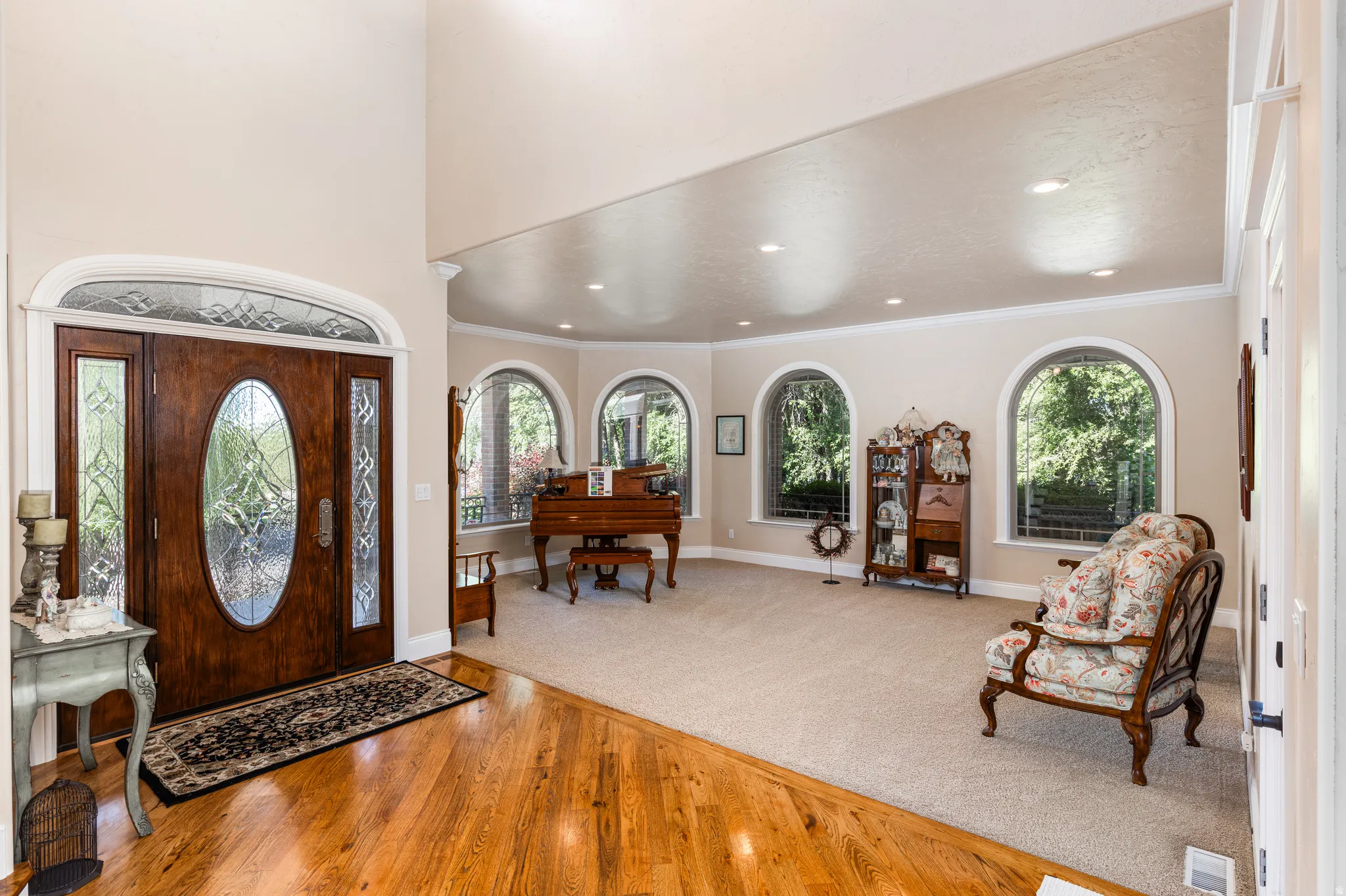 Grand entry with a custom wood door, stained glass sidelights, and an arched transom window