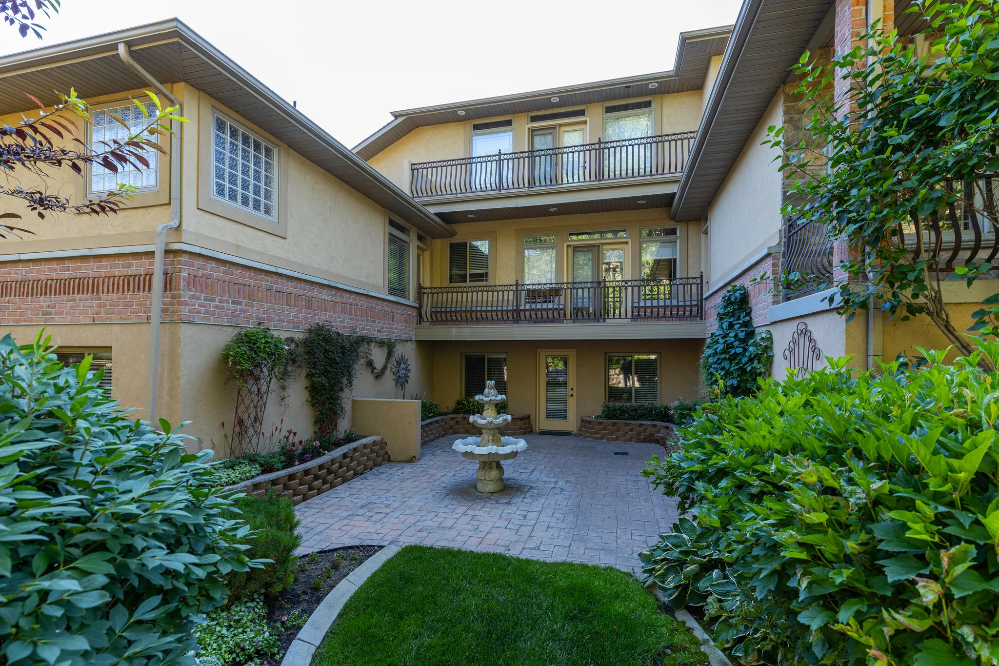 Private courtyard featuring a tiered fountain and paver flooring