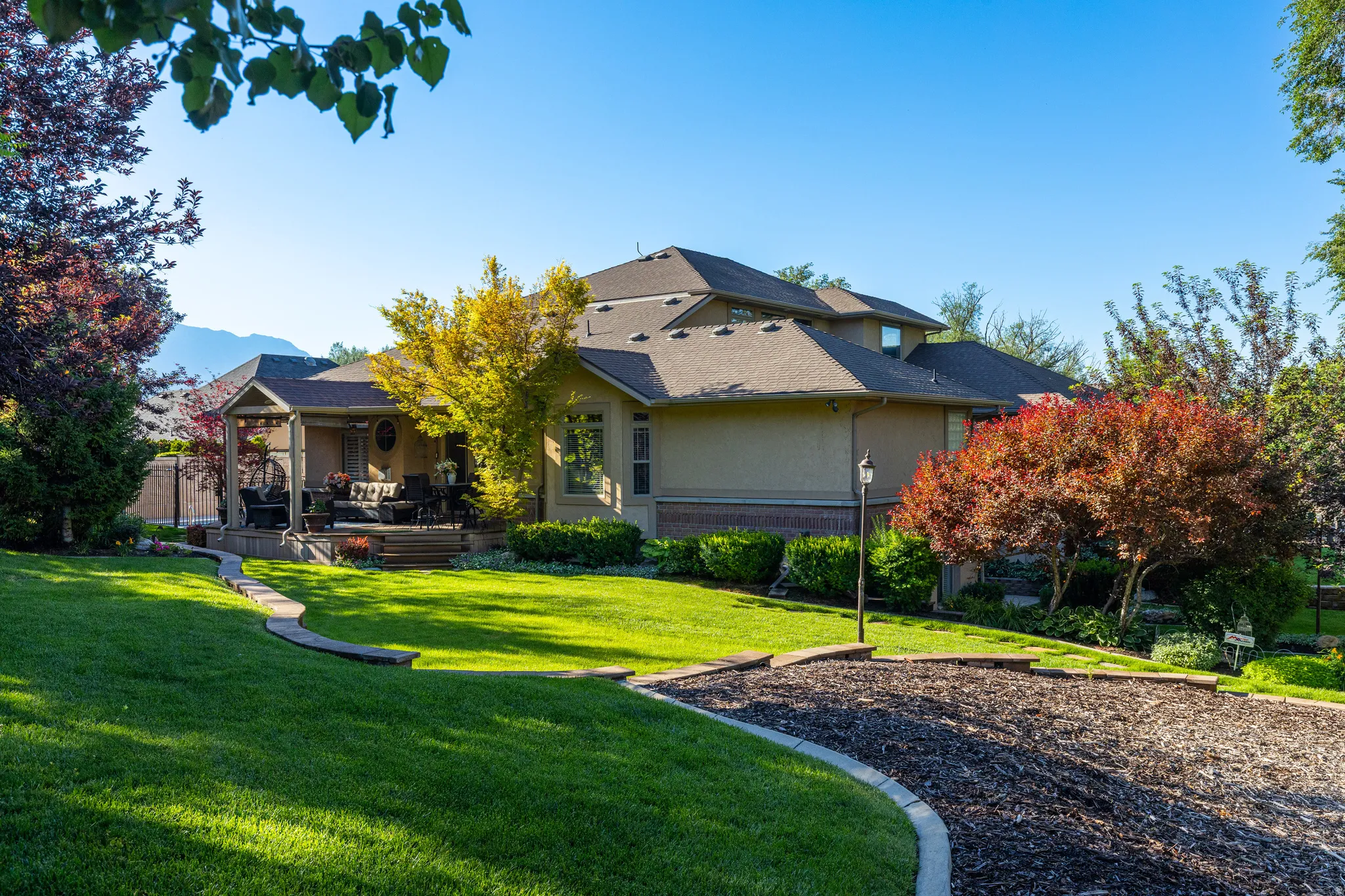Expansive manicured lawn with mature trees and landscaping