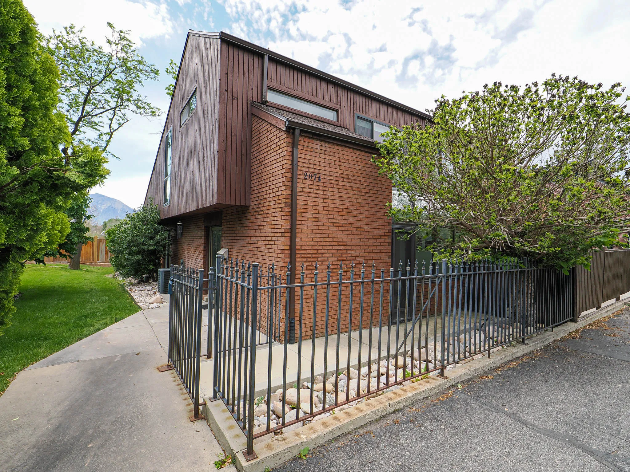 Brick and wood-sided exterior featuring a peaked roofline