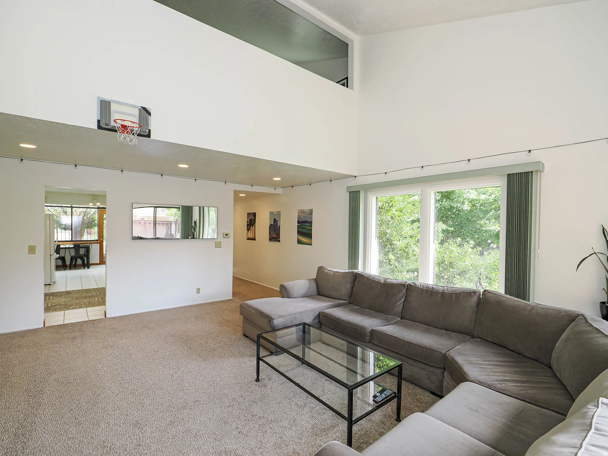 Living area with vaulted ceilings and abundant natural light from large windows