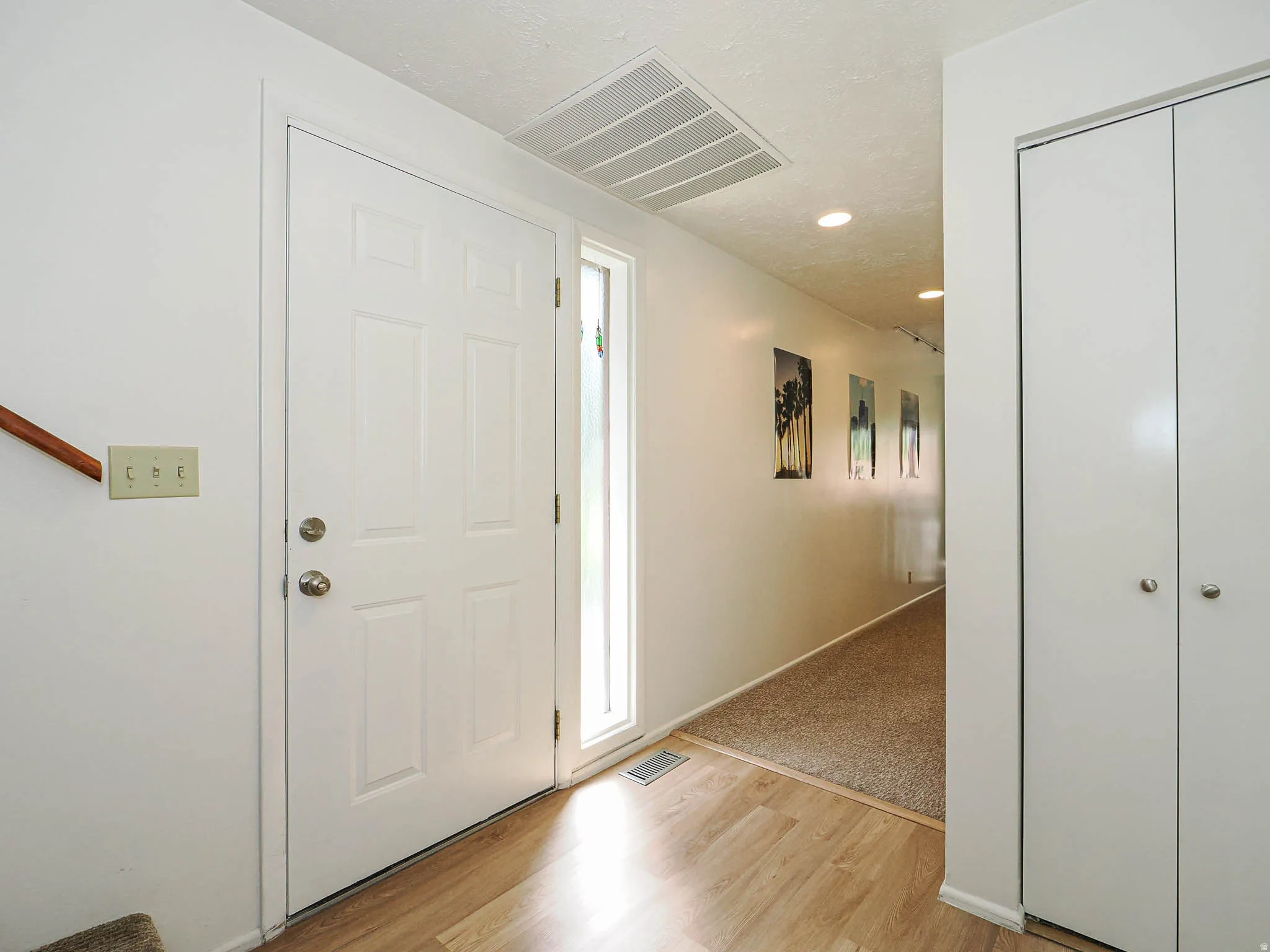 Entryway featuring a paneled door with a sidelight, wood-finish flooring, and a recessed lighting fixture