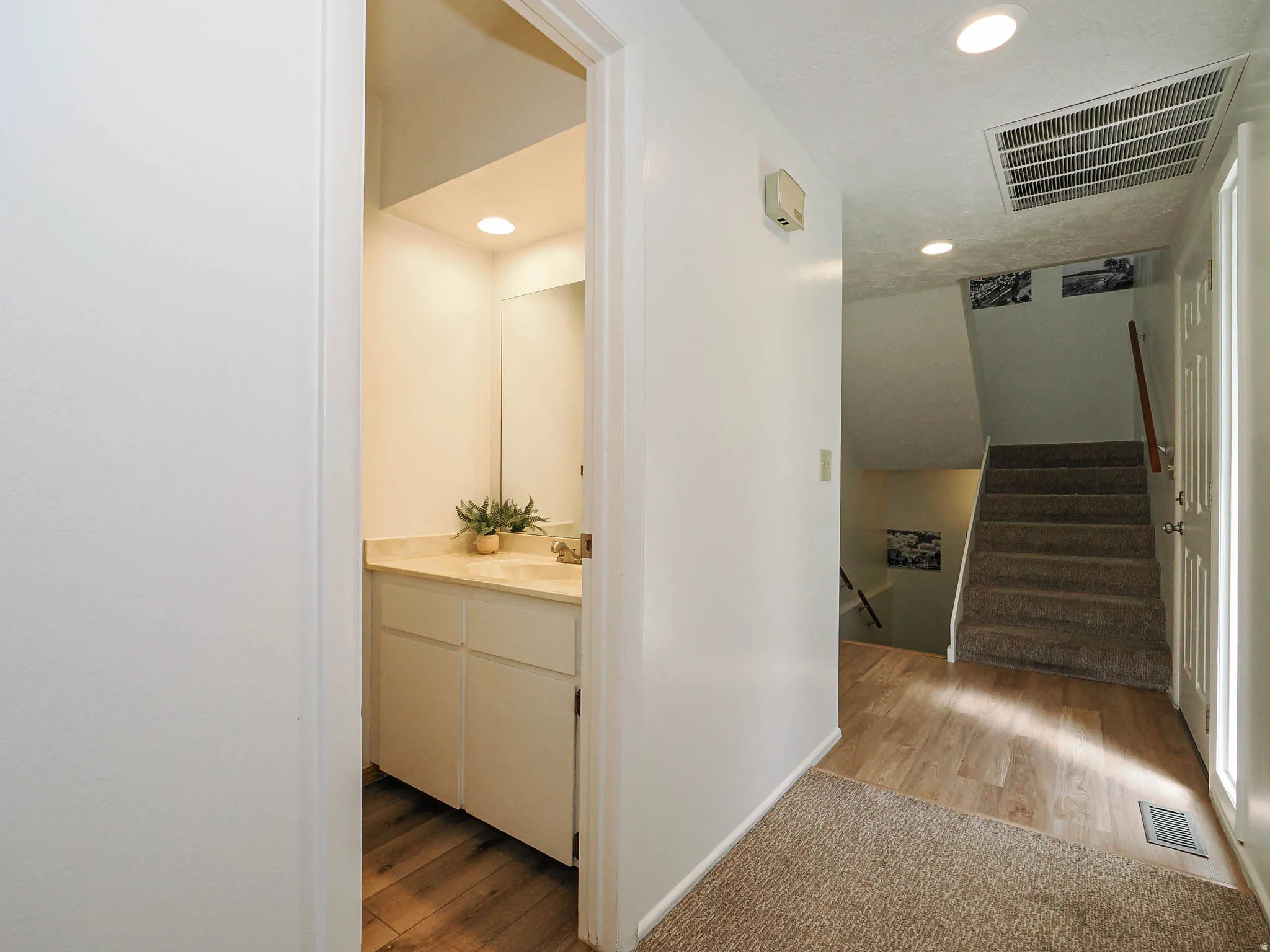 Powder room featuring a vanity with a light-toned countertop and recessed lighting