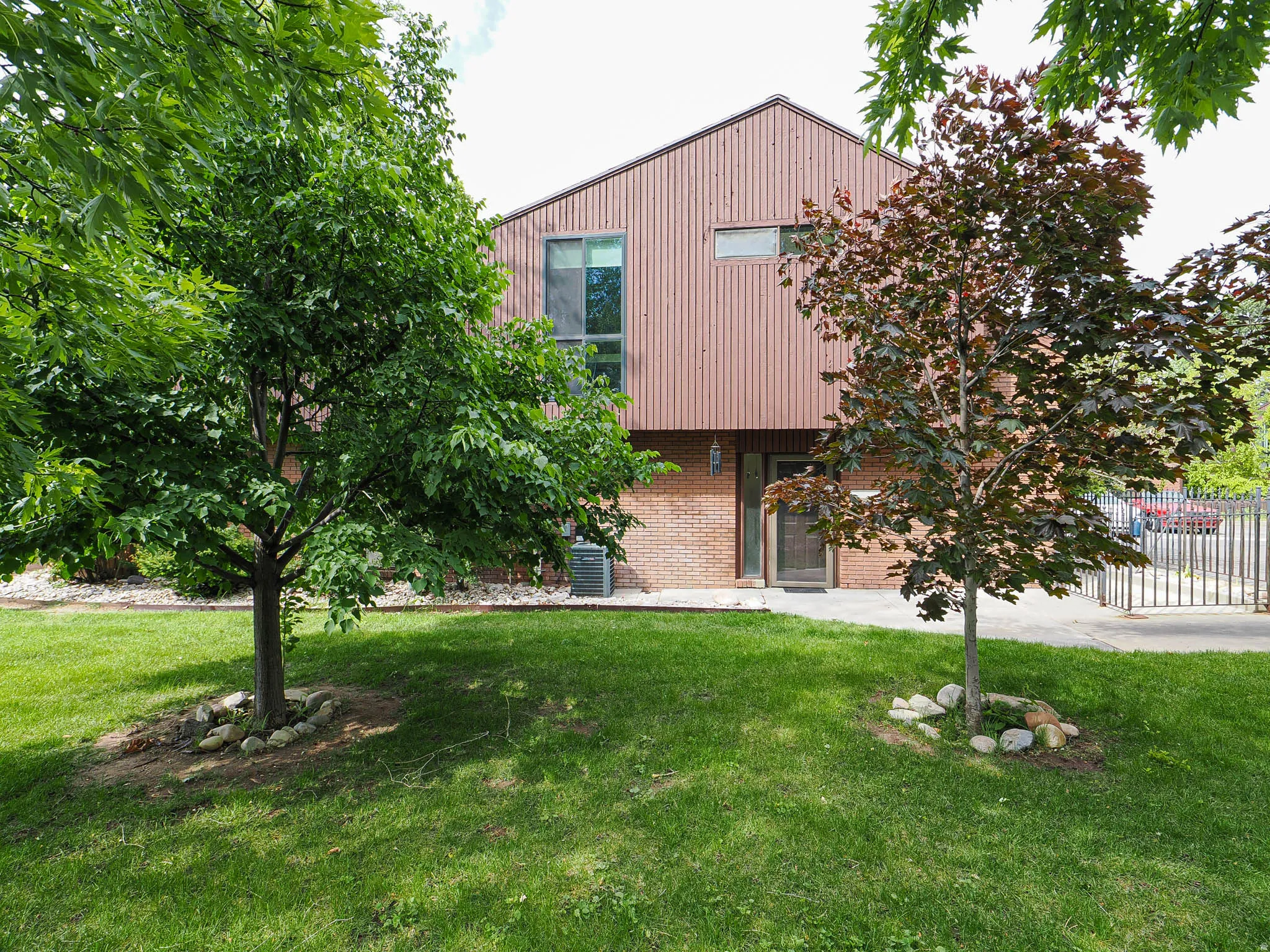 Exterior featuring vertical wood-finish siding and brickwork