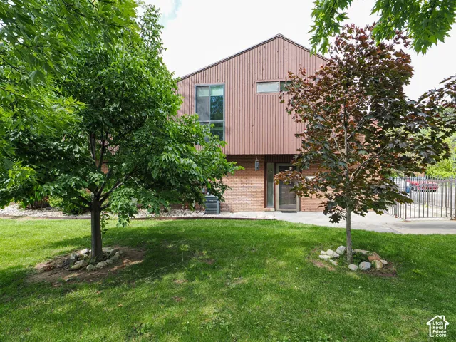 Exterior featuring vertical wood-finish siding and brickwork