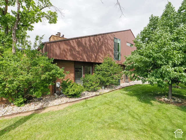 Two-story contemporary residence featuring vertical wood-finish siding and brick accents
