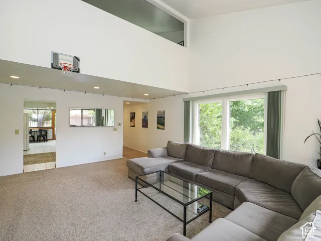 Living area with vaulted ceilings and abundant natural light from large windows
