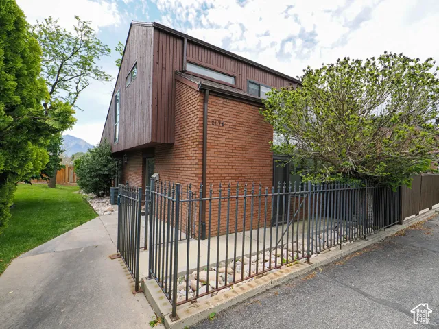 Brick and wood-sided exterior featuring a peaked roofline