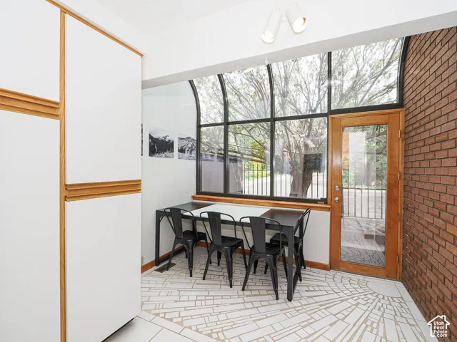 Floor-to-ceiling windows with arched transoms and a wood-frame glass door offer abundant natural light