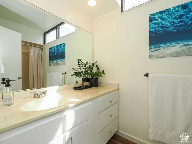 Bathroom vanity with a light-toned countertop, integrated sink, and white cabinetry