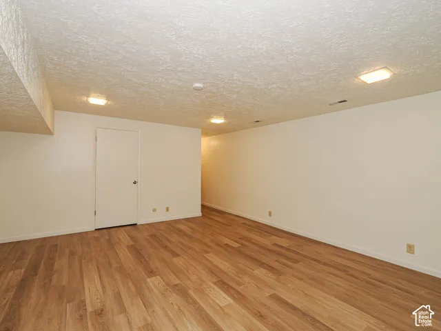Spacious interior room featuring wood-finish flooring, recessed lighting, and a neutral color palette
