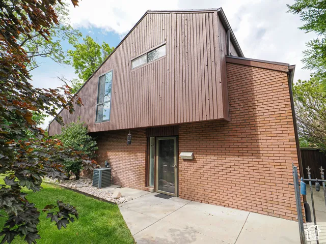 Contemporary architectural style featuring a prominent A-frame structure with vertical wood siding and brick accents