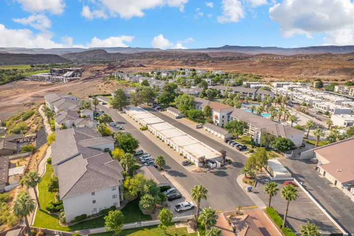 Aerial perspective showcasing a residential community with multiple buildings, paved parking areas, and mature landscaping