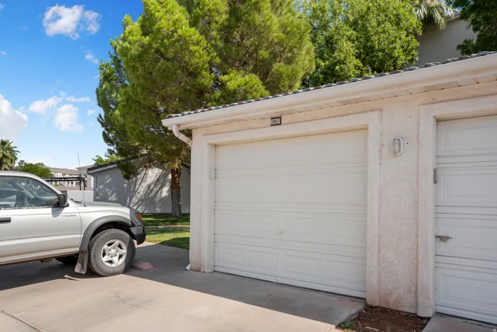 White garage doors with horizontal paneling, stucco exterior, and integrated rain gutters