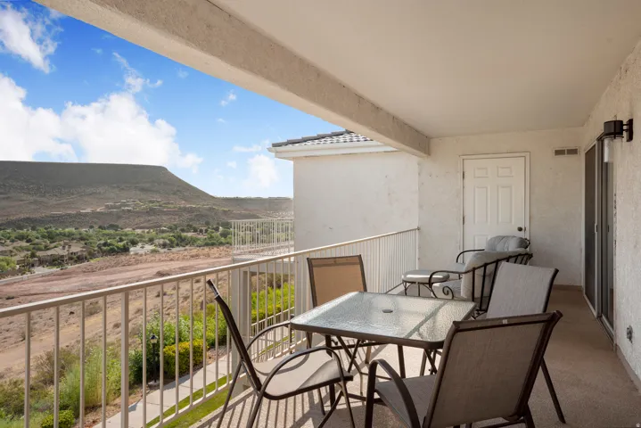 Covered balcony with a metal railing and expansive desert scenery