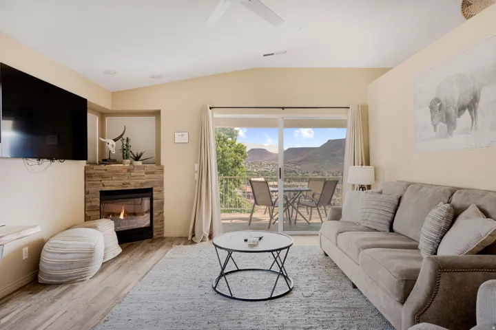 Living area featuring a stone-clad fireplace and wood-finish flooring