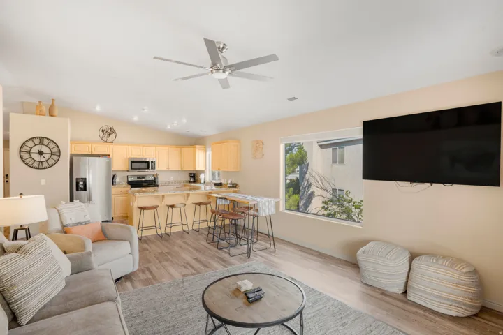 Open-concept living space featuring wood-finish flooring and a vaulted ceiling with a ceiling fan