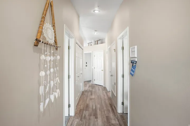 Hallway featuring wood-finish flooring, recessed lighting, and white paneled doors
