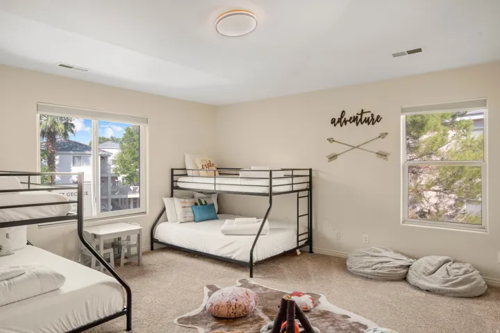 Spacious room with two large windows and neutral carpeting