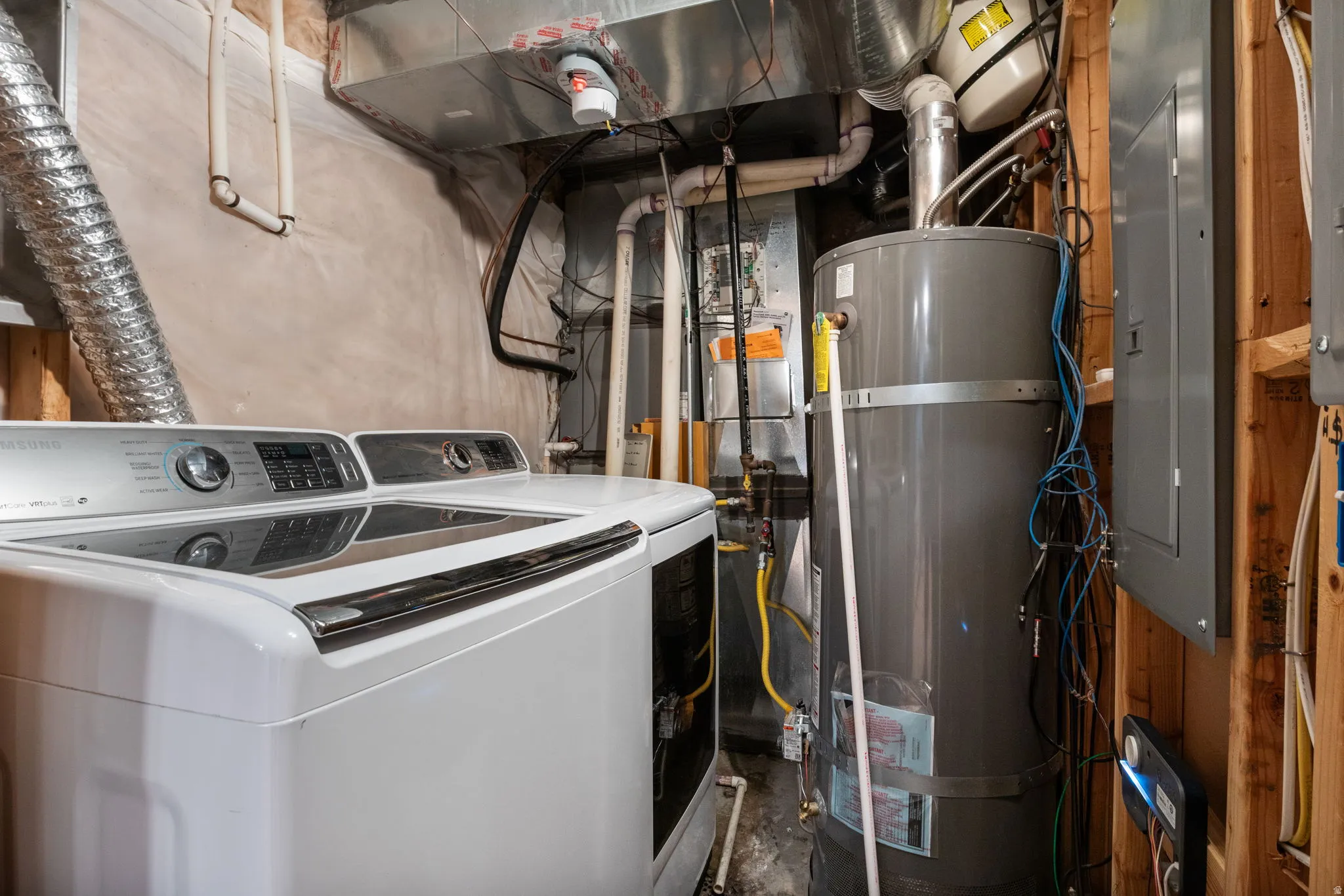 Dedicated utility area featuring a water heater, furnace, and electrical panel