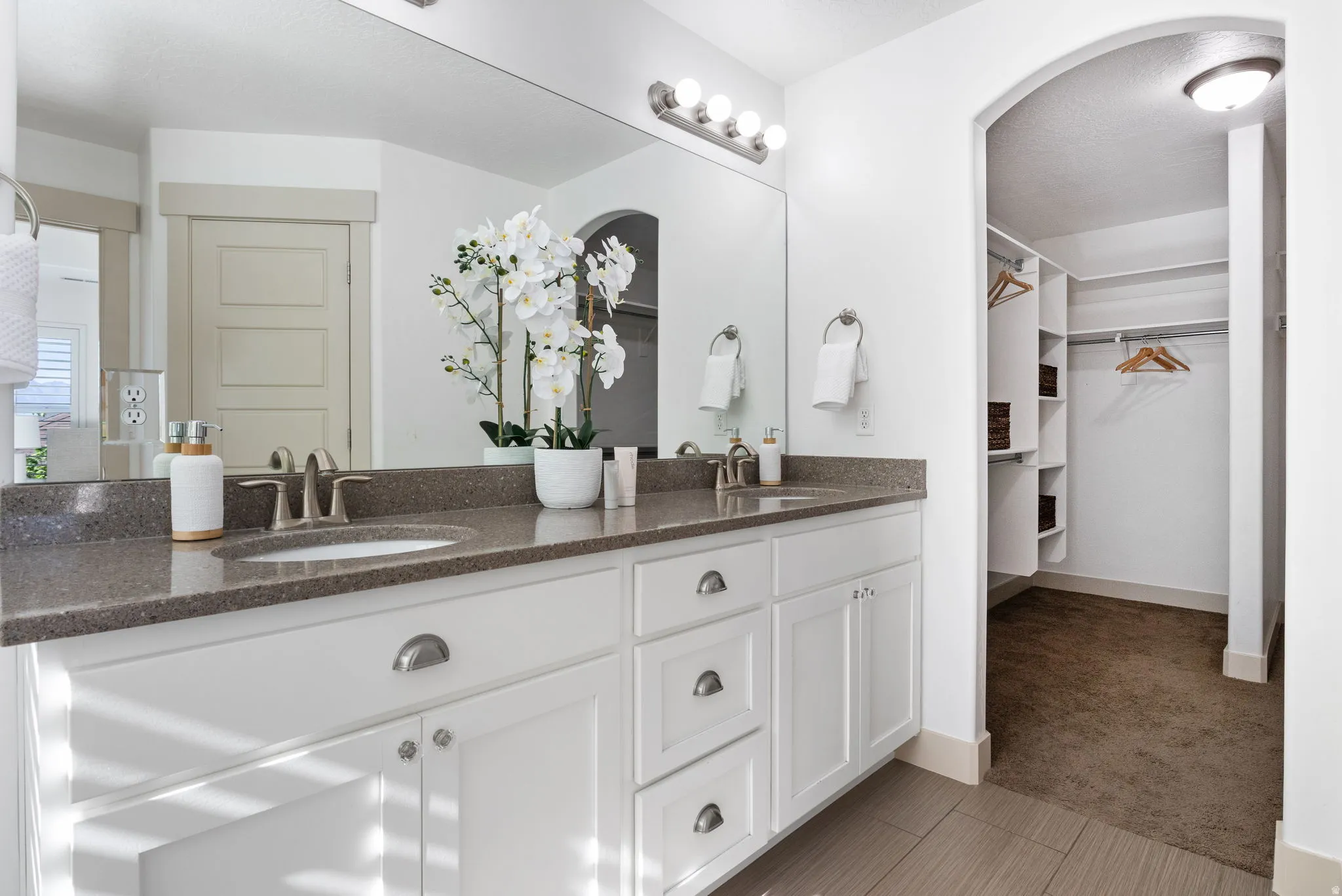 Double vanity featuring undermount sinks, brushed nickel fixtures, and a speckled countertop