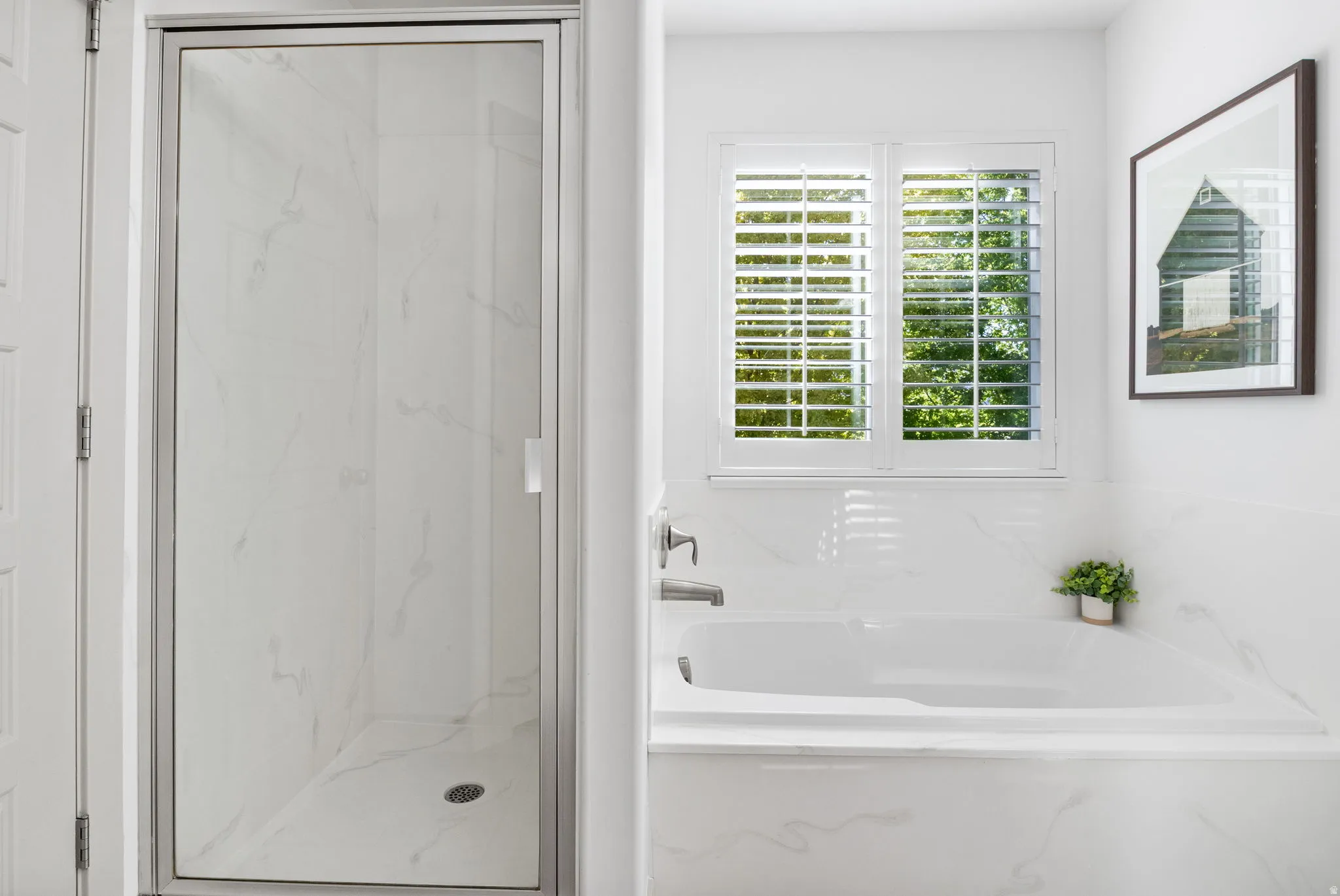 Full bathroom featuring a walk-in shower with a glass enclosure, a built-in bathtub, and white plantation shutters on the window